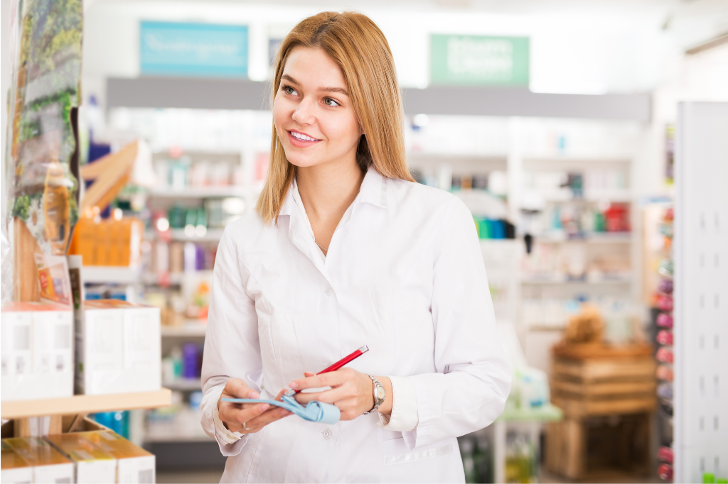 Γυναίκα φαρμακοποιός καταγράφει μπροστά σε ράφια φαρμακείου