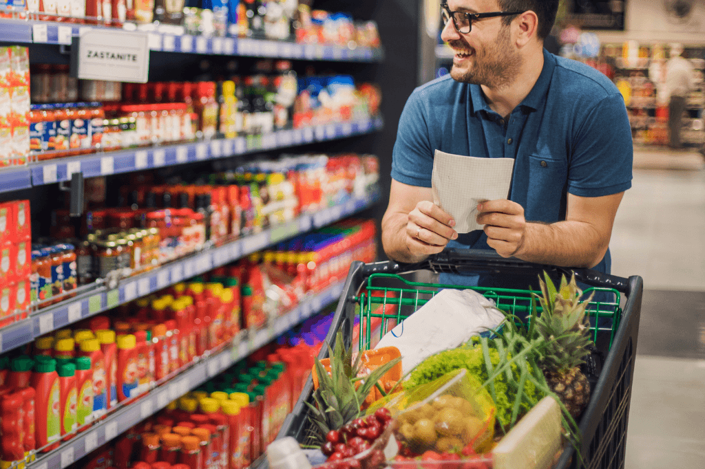 Ένας άντρας με γεμάτο καρότσι με τρόφιμα σε σούπερ μάρκετ