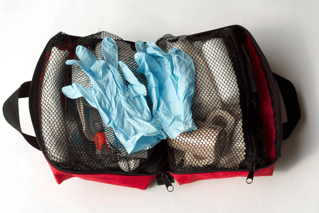 Ένα ανοιχτό τσαντάκι φαρμακείο αυτοκινήτου, με φαρμακευτικά είδη πρώτων βοηθειών.